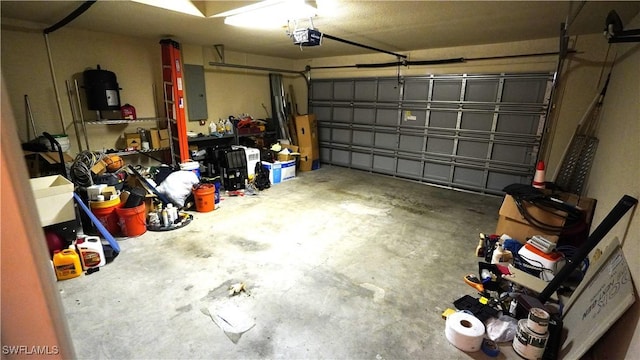 garage with a garage door opener and electric panel