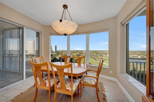 tiled dining room featuring a healthy amount of sunlight