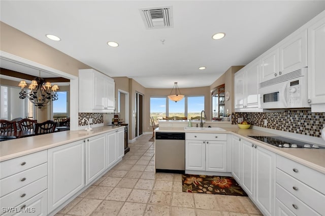 kitchen featuring hanging light fixtures, cooktop, tasteful backsplash, stainless steel dishwasher, and white cabinets