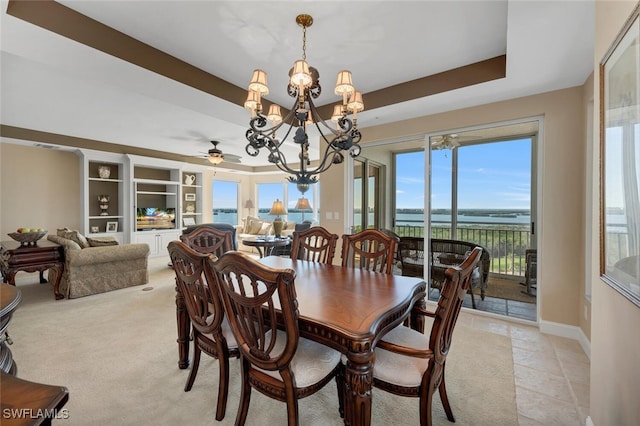 dining space with an inviting chandelier and a raised ceiling