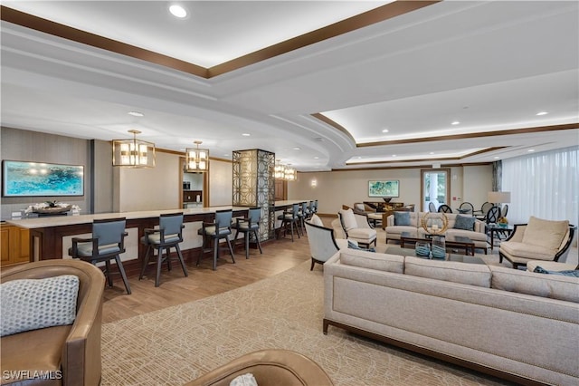 living room featuring light wood-type flooring and a tray ceiling