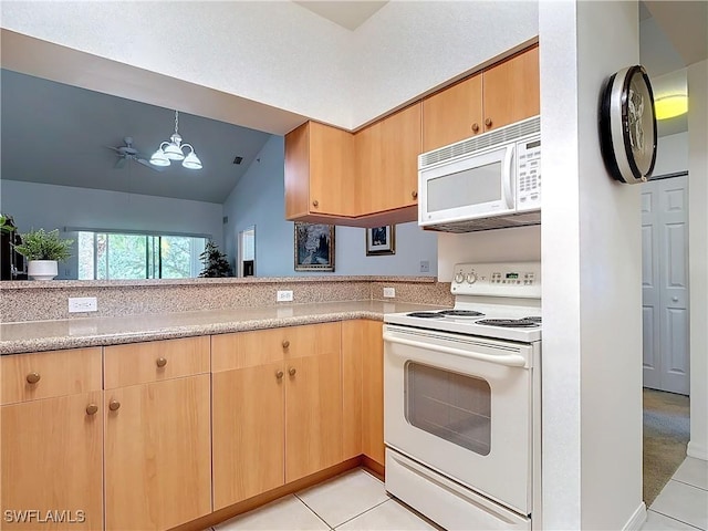 kitchen featuring white appliances, vaulted ceiling, an inviting chandelier, hanging light fixtures, and light tile patterned flooring