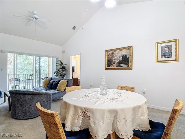 dining space featuring carpet flooring, ceiling fan, and high vaulted ceiling