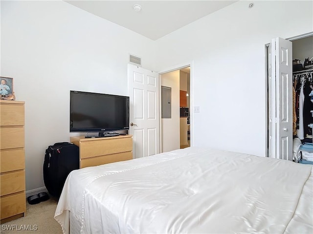 carpeted bedroom featuring electric panel and a closet