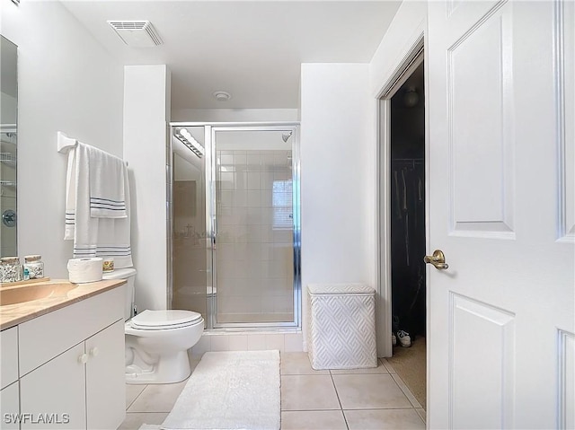 bathroom featuring tile patterned floors, vanity, an enclosed shower, and toilet