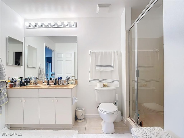 bathroom featuring tile patterned flooring, vanity, toilet, and an enclosed shower