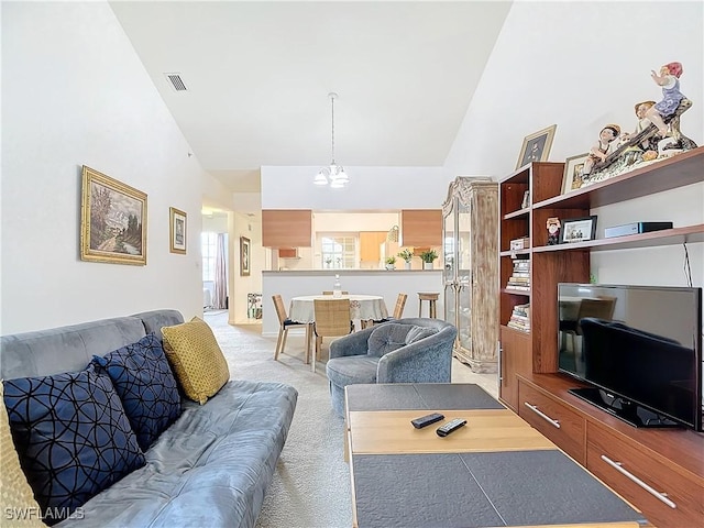 living room featuring carpet, high vaulted ceiling, and an inviting chandelier