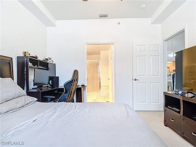 bedroom featuring ensuite bathroom and light colored carpet