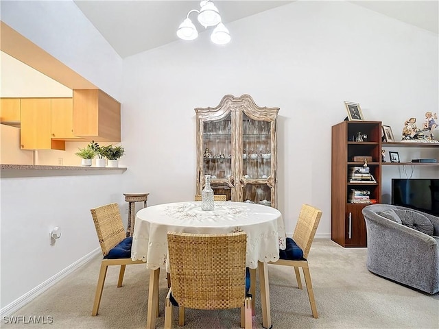 dining space with high vaulted ceiling and light colored carpet