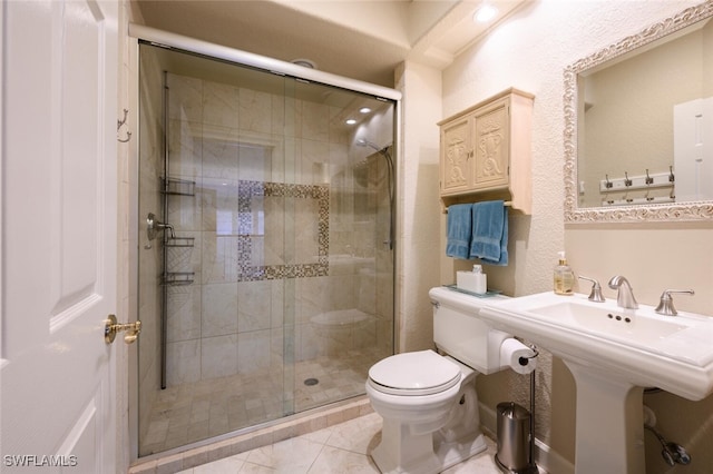 bathroom featuring tile patterned flooring, toilet, a shower with shower door, and sink