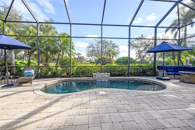 view of pool featuring glass enclosure, a patio, and an outdoor hangout area