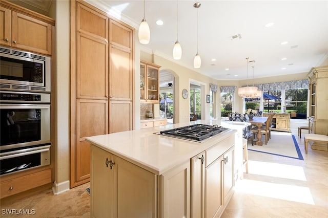 kitchen with stainless steel appliances, crown molding, an inviting chandelier, a center island, and hanging light fixtures