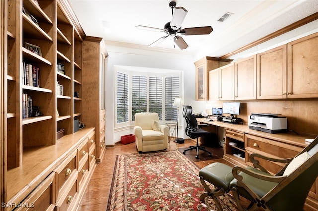 home office with crown molding, light hardwood / wood-style flooring, ceiling fan, and built in desk