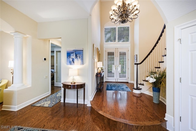 entrance foyer featuring a chandelier, french doors, hardwood / wood-style flooring, and a high ceiling