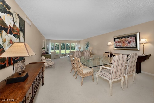 carpeted dining room featuring a textured ceiling