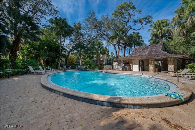 view of swimming pool featuring a patio and an outdoor structure