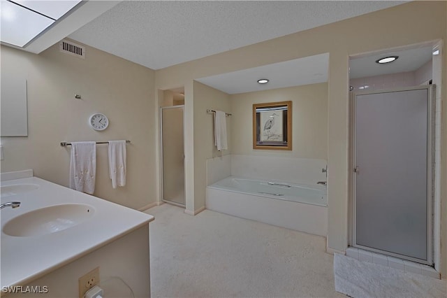 bathroom featuring vanity, independent shower and bath, and a textured ceiling