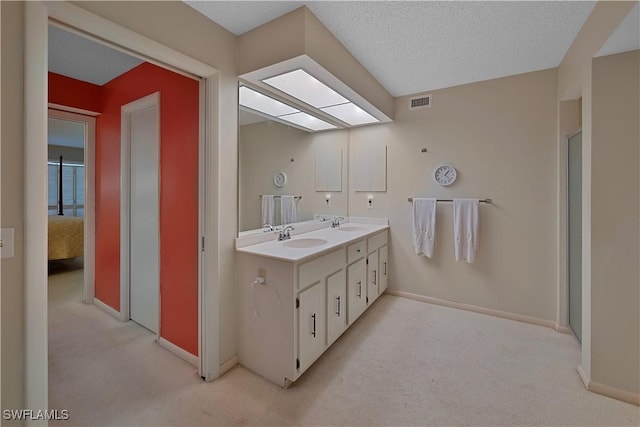 bathroom featuring a textured ceiling and vanity