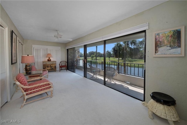 sunroom / solarium featuring ceiling fan and a water view