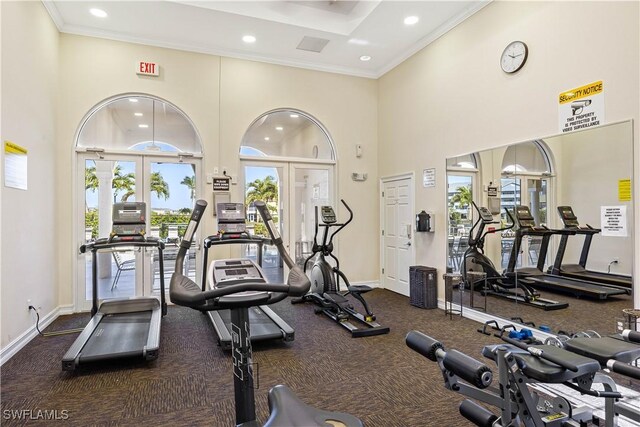 gym with a high ceiling, crown molding, and french doors