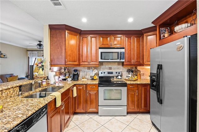 kitchen featuring ceiling fan, sink, light tile patterned flooring, light stone countertops, and appliances with stainless steel finishes