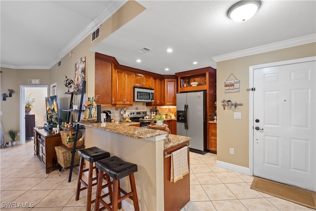 kitchen featuring kitchen peninsula, light tile patterned flooring, light stone counters, and stainless steel appliances