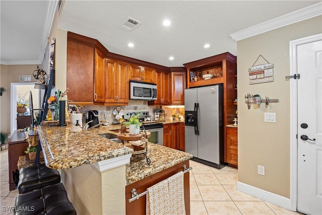 kitchen with stainless steel appliances, ornamental molding, kitchen peninsula, and light stone countertops