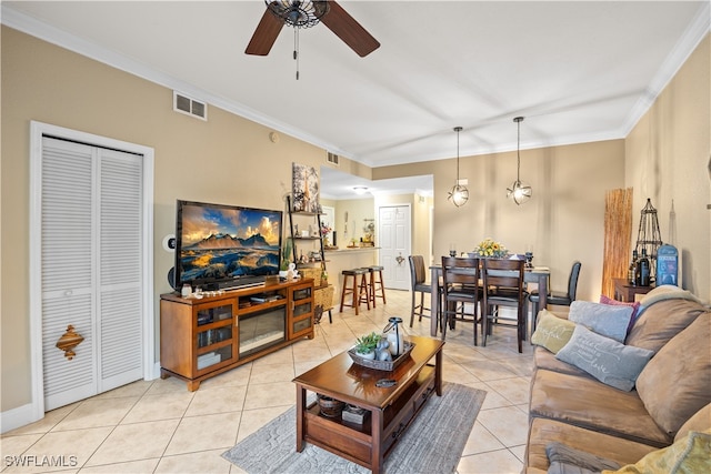 living room with ceiling fan, light tile patterned floors, and ornamental molding