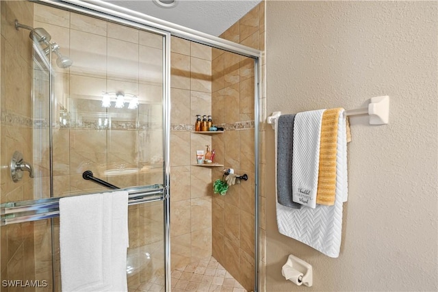 bathroom featuring a textured ceiling and walk in shower