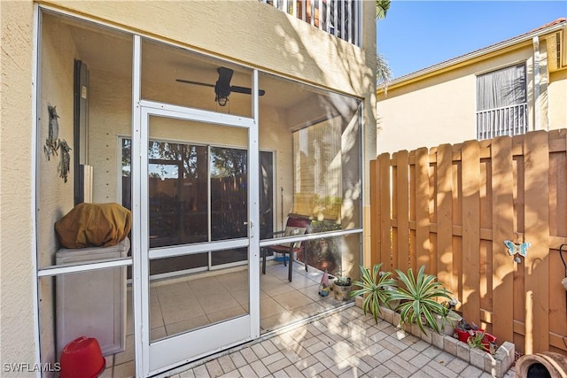 view of patio / terrace with ceiling fan and a sunroom