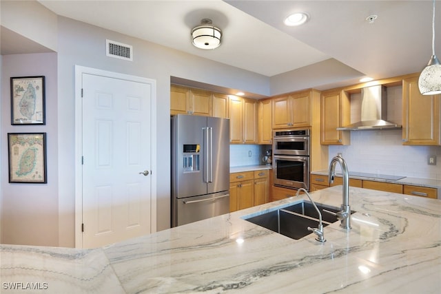 kitchen with wall chimney exhaust hood, stainless steel appliances, light stone counters, backsplash, and pendant lighting