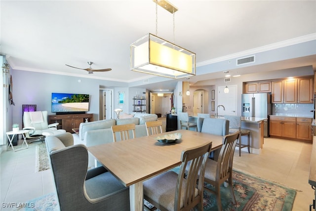 dining space featuring ceiling fan, crown molding, and light tile patterned flooring