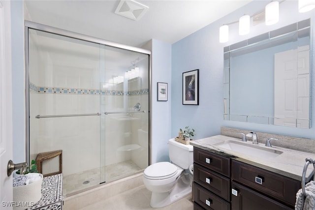 bathroom with tile patterned floors, vanity, toilet, and a shower with door