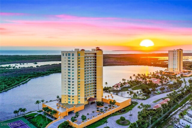 aerial view at dusk featuring a water view