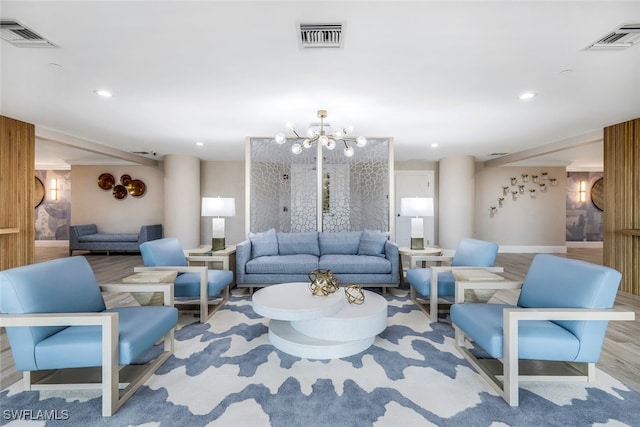 living room with light hardwood / wood-style flooring and an inviting chandelier