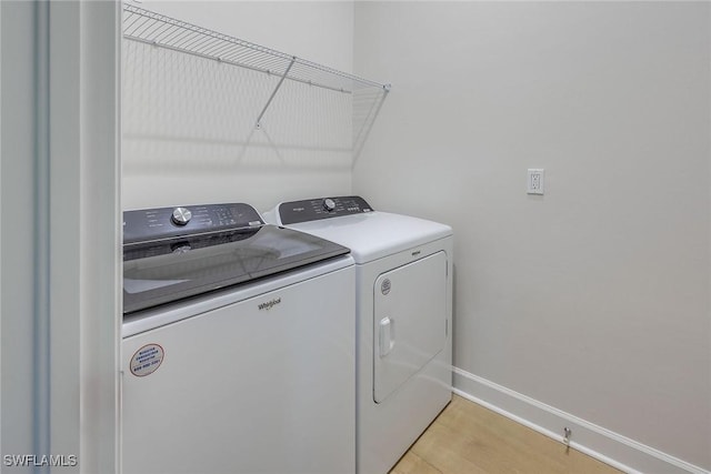 washroom featuring washer and dryer and light hardwood / wood-style floors