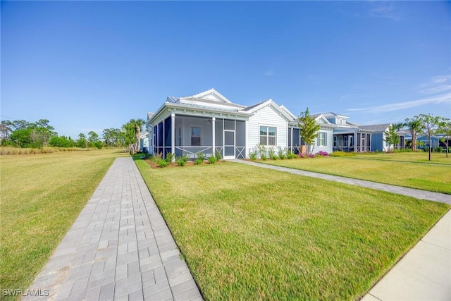 view of front of home with a front yard and a sunroom