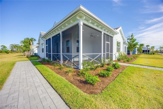 view of side of home with a sunroom and a lawn