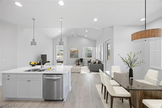 kitchen with dishwasher, sink, decorative light fixtures, white cabinets, and light wood-type flooring