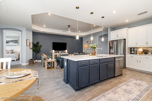 kitchen featuring pendant lighting, white cabinets, sink, ceiling fan, and appliances with stainless steel finishes