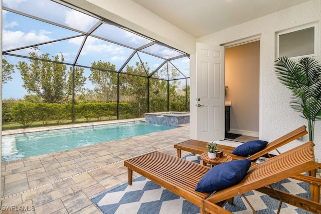 view of swimming pool featuring glass enclosure, a patio area, and an in ground hot tub