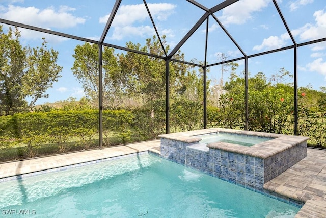 view of pool with pool water feature, a lanai, and an in ground hot tub