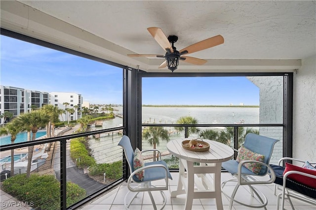 balcony with a water view and ceiling fan