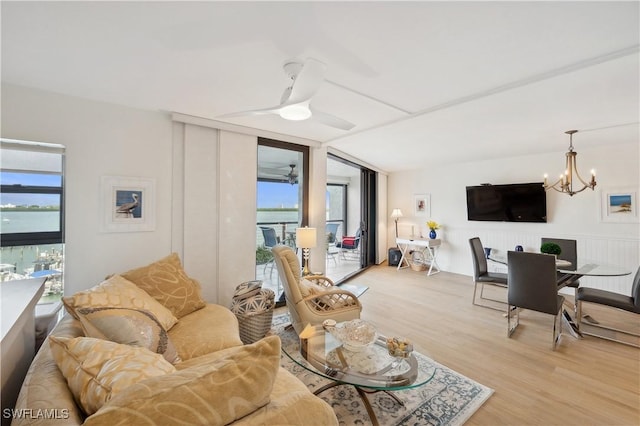 living room featuring light wood-type flooring and ceiling fan with notable chandelier