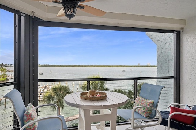 balcony featuring a water view and ceiling fan