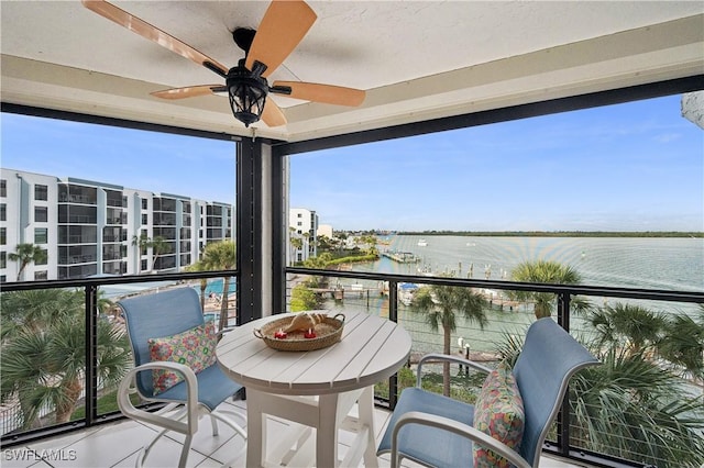 balcony with a water view and ceiling fan