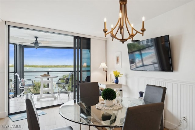 dining area featuring floor to ceiling windows and ceiling fan with notable chandelier