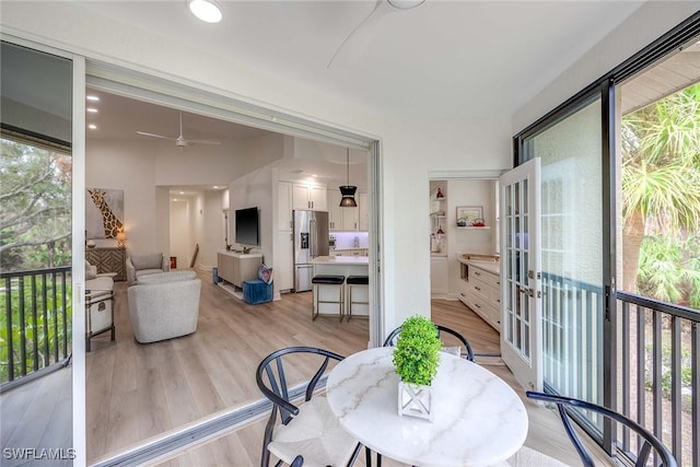 sunroom featuring ceiling fan and french doors