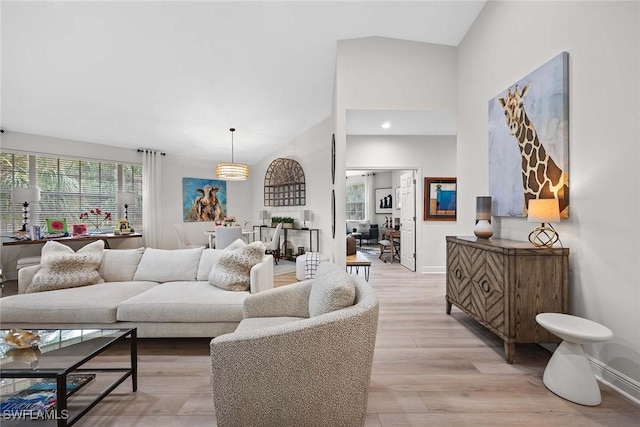 living room with light hardwood / wood-style flooring and high vaulted ceiling