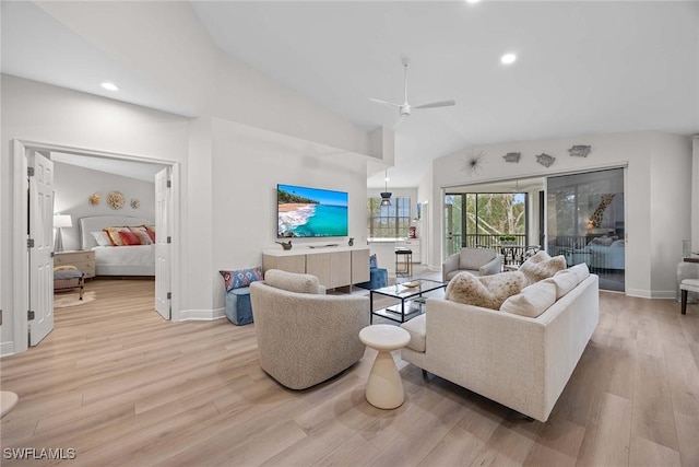 living room featuring ceiling fan, light hardwood / wood-style floors, and vaulted ceiling